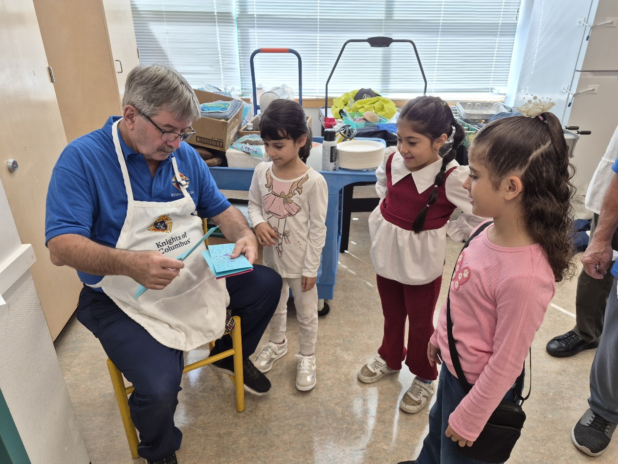 A Brother Knight chatting with students